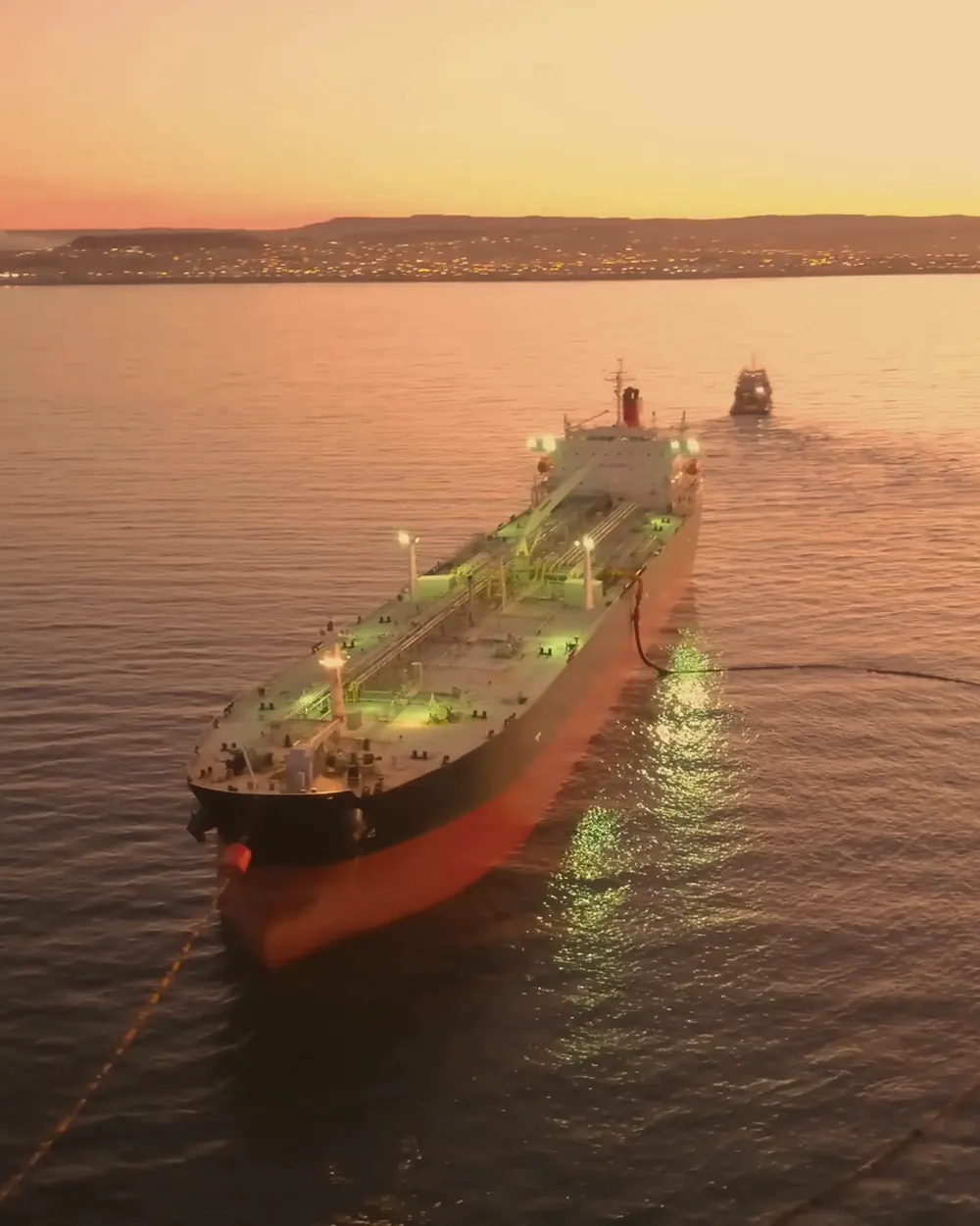 A tanker at anchor on calm water at sunset